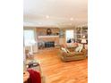 Cozy living room with hardwood floors, a brick fireplace, and built-in bookshelves at 453 Cotton Ct, York, SC 29745
