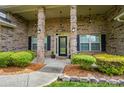 Home has a quaint front porch with brick pillars, flower pots, and a decorative front door at 5032 Eagles Crest Ln, Gastonia, NC 28056