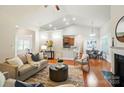 Open-concept living space featuring hardwood floors, vaulted ceilings, and seamless kitchen access at 5032 Eagles Crest Ln, Gastonia, NC 28056