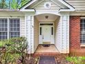 Home's inviting front entrance features a covered porch and decorative door with sidelights at 6520 White Pine Ln, Charlotte, NC 28262