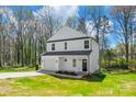 White two-story home on a green lawn features an attached garage, a concrete driveway, and an inviting front entrance at 701 Applewood St, Kannapolis, NC 28081