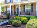 Inviting front porch with classic columns, rod iron railings and lush landscaping at 706 Springwood Dr # 14, Waxhaw, NC 28173
