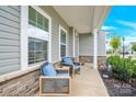 Relaxing front porch with comfortable seating, showcasing the entrance to the home and well-kept landscaping at 7278 Waterwheel St, Concord, NC 28025