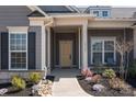Inviting front entrance with elegant door, decorative sidelights, and manicured landscaping featuring river rock and seasonal flowers at 12709 Messenger Row, Huntersville, NC 28078