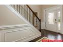 Elegant foyer with hardwood floors, a staircase with wrought iron railings, and a front door with decorative glass at 130 Fordingbridge Ln, Mooresville, NC 28115