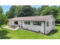 Well-manicured lawn surrounds this freshly renovated white brick home with new shutters, lighting, and garage at 1315 Vickie Ln, Matthews, NC 28104