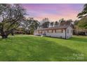 Charming white brick home with a well-manicured lawn and lovely trees in a quiet neighborhood at 1315 Vickie Ln, Matthews, NC 28104