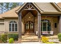 Inviting covered front porch with stone detailing, wood columns and stylish outdoor seating at 135 Frostcliff Ln, Mooresville, NC 28117