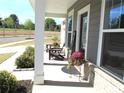 Charming front porch featuring comfortable seating, flowers, and classic architectural details at 19412 Bird Meadow Dr, Huntersville, NC 28078