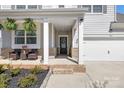 Inviting front porch with brick accents, seating, and decorative plants, leading to the front door and garage at 3013 Whipcord Dr, Waxhaw, NC 28173