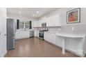 Bright kitchen with white cabinets, stainless steel appliances, and hardwood floors, ready for culinary adventures at 3013 Whipcord Dr, Waxhaw, NC 28173