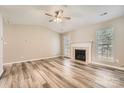 Spacious living room boasts a fireplace, ceiling fan, and wood-look flooring at 3023 Fairglen Rd, Charlotte, NC 28269