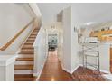 Inviting hallway featuring hardwood floors and an open staircase with natural light at 3048 Misty Harbor Cir # E, Cramerton, NC 28032