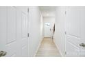 Bright hallway with light wood floors, white walls, and a door with a decorative glass insert at 3052 Ora Smith Rd, Lincolnton, NC 28092