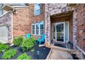 Inviting front porch with brick facade and blue chairs, enhanced by lush landscaping at 324 Kerrydale Ct # 106, Clover, SC 29710