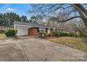 Red brick home with a covered carport and a lush front yard with mature trees at 3509 Havenwood Rd, Dallas, NC 28034