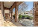 Inviting front porch with stone columns and a rocking chair, perfect for relaxation at 3613 Martele Dr, Mint Hill, NC 28227
