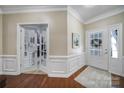 Elegant foyer featuring hardwood floors, detailed moldings, and a view through glass doors into an office at 45008 Wigeon Ln # 101, Indian Land, SC 29707