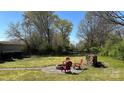 Spacious backyard with a fire pit, red Adirondack chairs, and a wood pile at 4807 Lon Parker Rd # 1, Waxhaw, NC 28173