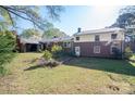 Expansive backyard showcases the home's rear exterior with well-kept lawn and mature trees at 521 Hawthorne Ln, Gastonia, NC 28054