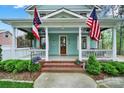 Inviting front porch with American flags, classic columns, and manicured shrubs enhancing the curb appeal at 110 Sonnys Way, Fort Mill, SC 29708