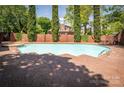 Community pool featuring a brick surround, mature trees, and wrought iron fencing, perfect for relaxation at 1101 E Morehead St # 31, Charlotte, NC 28204
