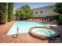 Relaxing community pool and hot tub area with ample seating and mature trees for shade at 1101 E Morehead St # 31, Charlotte, NC 28204