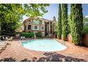 Community pool area with a sparkling pool, lush greenery and manicured trees surrounding the building at 1101 E Morehead St # 31, Charlotte, NC 28204