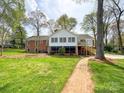 Expansive backyard with a brick walkway leading to a lush green lawn and mature trees at 12011 Stoney Meadow Dr, Mint Hill, NC 28227