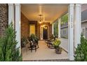 Inviting front porch featuring rocking chairs, pendant lighting, and a brick facade at 12912 Bailey Rd, Cornelius, NC 28031