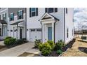 Charming townhouse with a light blue front door, attached garage, and neatly manicured shrubbery at 13304 Porter Creek Rd, Charlotte, NC 28262