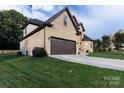 Side view of a brick home with a two car garage, and a well manicured lawn at 1358 37Th Avenue Ne Pl, Hickory, NC 28601