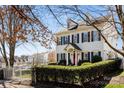 Well-maintained home featuring dormer windows, black shutters, and mature landscaping at 14024 Alley Son St, Huntersville, NC 28078