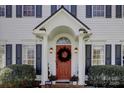 Inviting front entrance with an arched entryway, red door with a decorative wreath, and flanking plants at 14024 Alley Son St, Huntersville, NC 28078