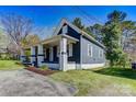 Side view of a single-Gathering home featuring a covered porch, painted brick accents, and landscaped yard at 209 N Yadkin Ave, Spencer, NC 28159