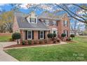 Attractive brick home with black shutters, trimmed shrubs, and well-maintained lawn on a sunny day at 21721 Shoveller Ct, Cornelius, NC 28031