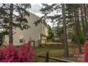 Spacious backyard with a wooden fence, deck, and beautiful landscaping with some pink flowers at 2919 Bridgeville Ln, Charlotte, NC 28262