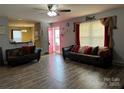 Inviting living room featuring wood-look floors, comfortable seating, and an open doorway at 300 S Oakland Ave, Statesville, NC 28677