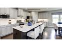 Modern kitchen with stainless steel appliances, a large island with seating, and sleek cabinetry at 3008 Bramble Hedge Dr # 3272, Indian Trail, NC 28079
