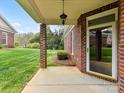Covered outdoor patio area featuring brick columns and view of backyard at 3721 Oak View Ct, Matthews, NC 28105
