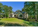 Spacious brick home with well-maintained lawn, mature trees, and architectural details at 4586 Chanel Ct, Concord, NC 28025