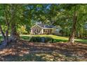 Stately brick home nestled among mature trees with a manicured front lawn at 4586 Chanel Ct, Concord, NC 28025