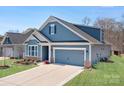 Charming blue two-story home with a two-car garage and meticulously maintained lawn at 5025 Antebellum Dr, Iron Station, NC 28080