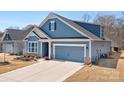 Charming blue two-story home with a two-car garage and meticulously maintained lawn at 5025 Antebellum Dr, Iron Station, NC 28080