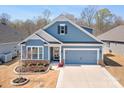 Charming blue two-story home featuring a two-car garage and beautifully landscaped front yard at 5025 Antebellum Dr, Iron Station, NC 28080