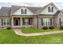 Close up view of the front exterior with a brick facade, black shutters, and a well-kept lawn at 514 Baucom Deese Rd, Monroe, NC 28110