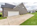 View of the attached two-car garage with a wide driveway and a detached garage in the background at 514 Baucom Deese Rd, Monroe, NC 28110