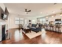 Open-concept living room with hardwood floors, fireplace, and seamless connection to the kitchen and dining area at 525 Cellini Pl, Mount Holly, NC 28120
