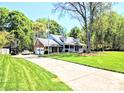 Attractive home with a well-manicured lawn and a long driveway leading to an attached garage at 5344 Saddlewood Ln, Mint Hill, NC 28227