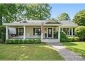 Inviting single-story house featuring a covered porch with rocking chairs and swing at 5400 Glenham Dr, Charlotte, NC 28210